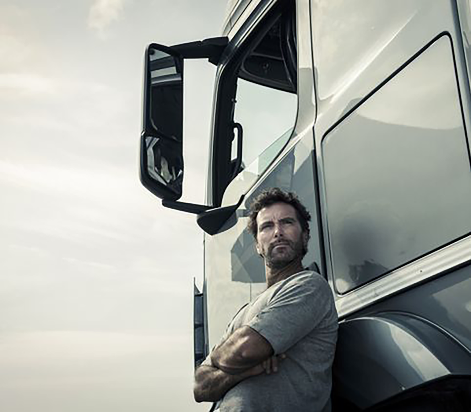 A man poses next to a truck